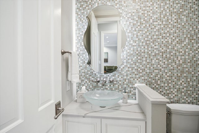 bathroom featuring tasteful backsplash, vanity, toilet, and tile walls