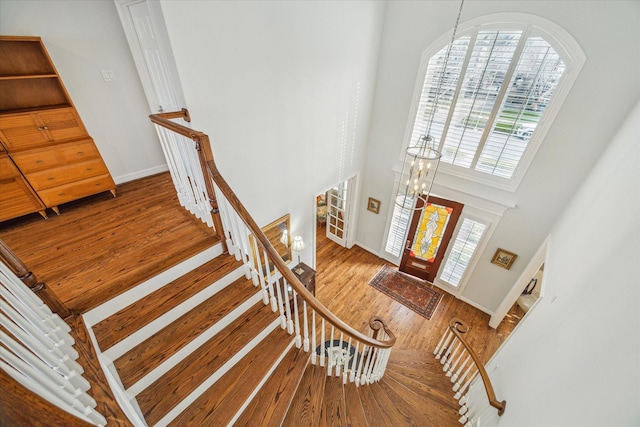 entryway featuring hardwood / wood-style floors, a chandelier, and a high ceiling