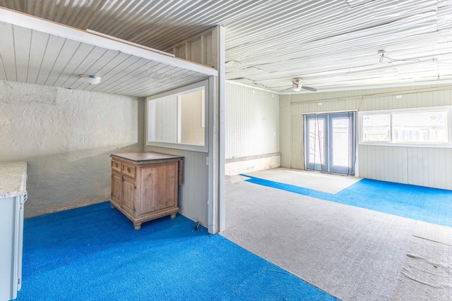 interior space with dark carpet and ceiling fan