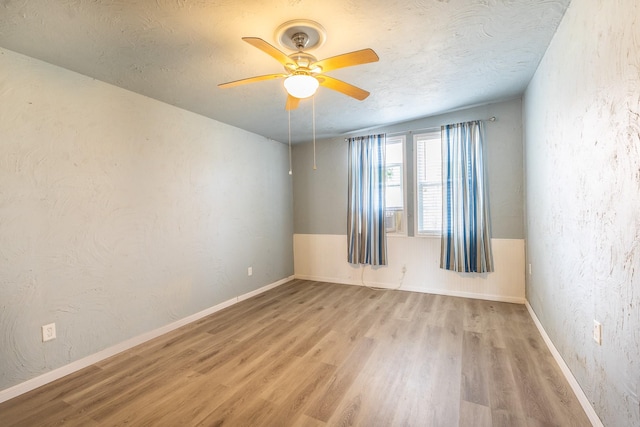 spare room with ceiling fan, light hardwood / wood-style floors, and a textured ceiling