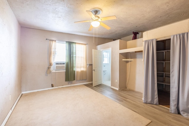 unfurnished bedroom featuring cooling unit, ceiling fan, hardwood / wood-style floors, and a textured ceiling