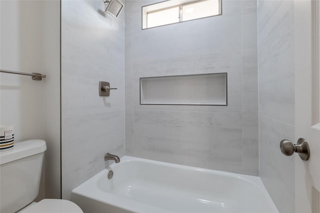 bathroom with tiled shower / bath and toilet