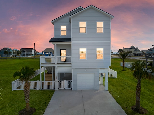 view of front of property featuring a yard, a garage, and covered porch