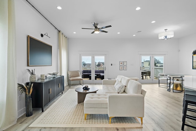 living room featuring ceiling fan, a healthy amount of sunlight, and light hardwood / wood-style floors