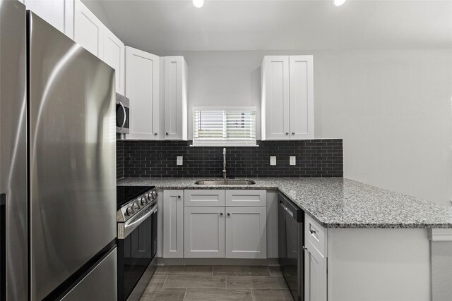 kitchen with sink, light stone countertops, white cabinets, and appliances with stainless steel finishes