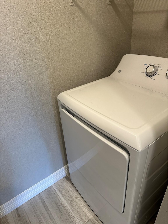 laundry area with washer / dryer and light hardwood / wood-style flooring