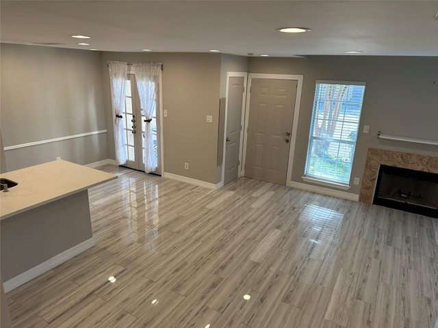 interior space with a fireplace, light hardwood / wood-style flooring, and french doors