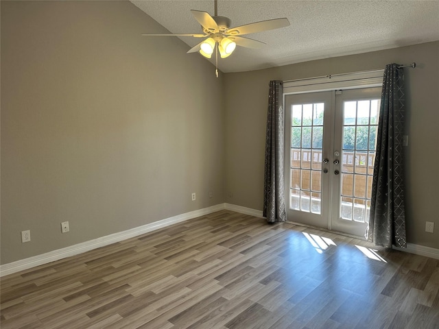 spare room featuring french doors, lofted ceiling, ceiling fan, a textured ceiling, and light hardwood / wood-style flooring