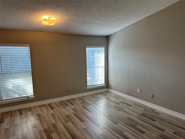 empty room featuring light hardwood / wood-style floors and a textured ceiling