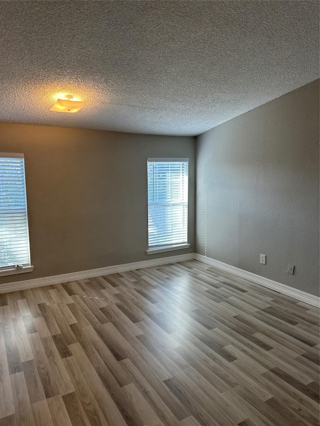 spare room with hardwood / wood-style flooring and a textured ceiling