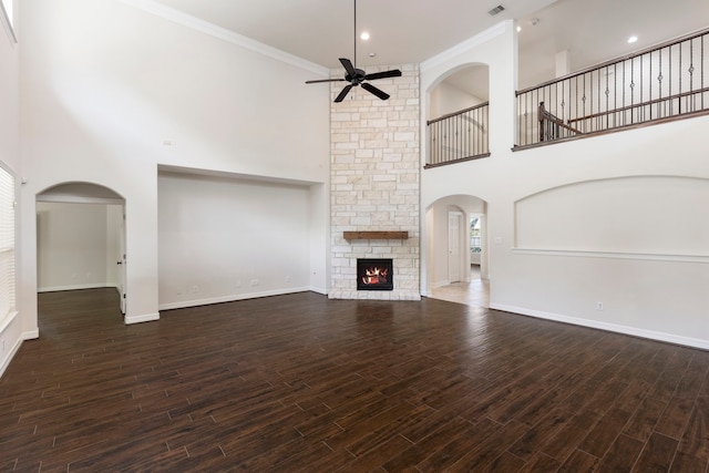 unfurnished living room with crown molding, a fireplace, dark hardwood / wood-style floors, and ceiling fan