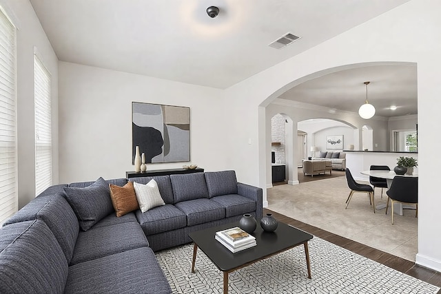 living room featuring a wealth of natural light, ornamental molding, and hardwood / wood-style floors