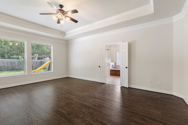 spare room featuring a tray ceiling, dark wood-type flooring, ornamental molding, and ceiling fan