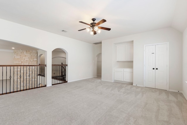 empty room with ceiling fan and light carpet