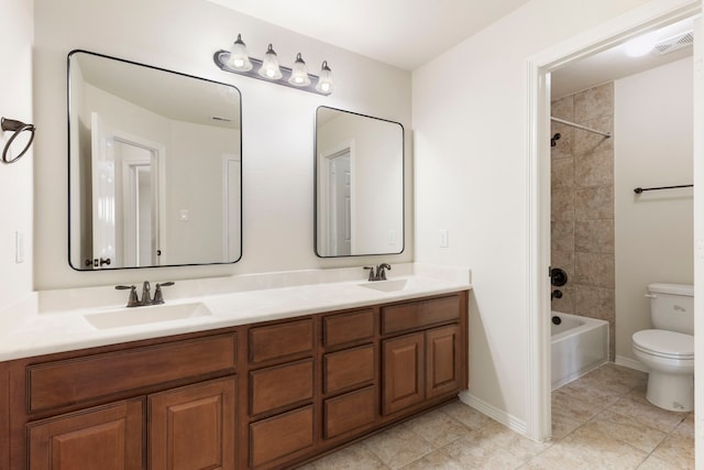 full bathroom featuring tiled shower / bath, vanity, toilet, and tile patterned floors