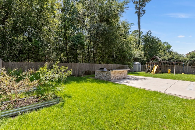 view of yard featuring a storage shed, a playground, and a patio area