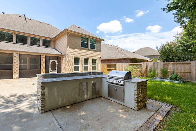 view of patio featuring area for grilling, exterior kitchen, and sink