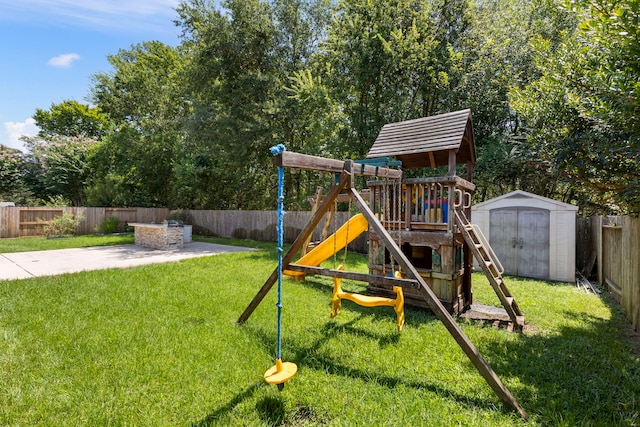 view of play area with a shed, a yard, and a patio