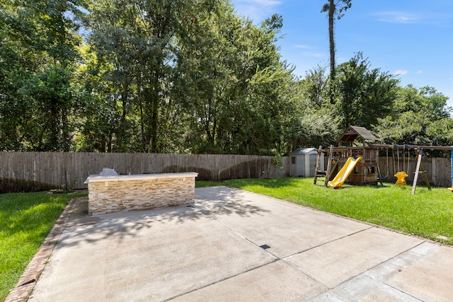 view of patio / terrace with a playground and a storage unit