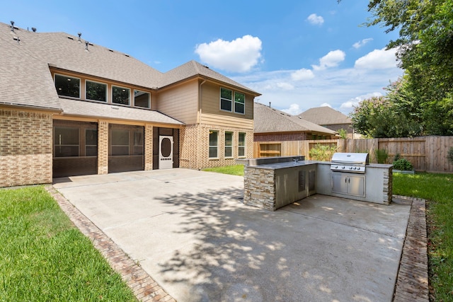 view of patio with exterior kitchen and a grill