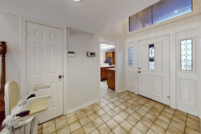 tiled foyer entrance with a textured ceiling