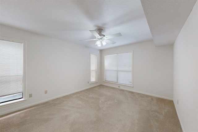 carpeted empty room featuring ceiling fan and a textured ceiling