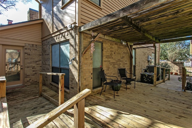 wooden terrace with a pergola and a fire pit