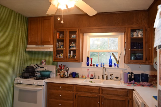 kitchen with dishwasher, sink, white gas stove, and ceiling fan