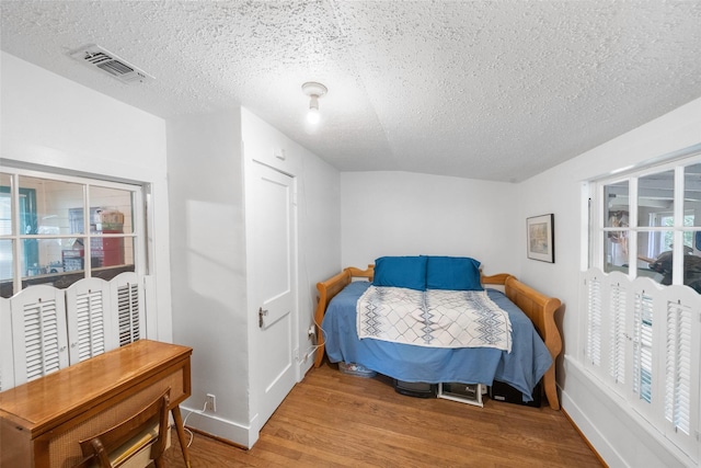 2506 Brazeal St, Waller, TX 77484 - bedroom with a textured ceiling, visible vents, wood finished floors, and baseboards