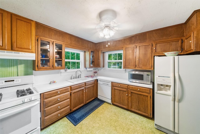 2506 Brazeal St, Waller, TX 77484 - kitchen with a sink, white appliances, brown cabinets, under cabinet range hood, and ceiling fan