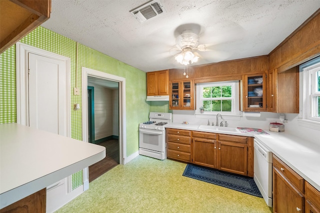 2506 Brazeal St, Waller, TX 77484 - kitchen featuring under cabinet range hood, visible vents, brown cabinets, and white appliances