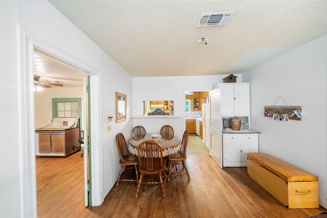 2506 Brazeal St, Waller, TX 77484 - dining space with a textured ceiling, a wealth of natural light, light wood-type flooring, and visible vents