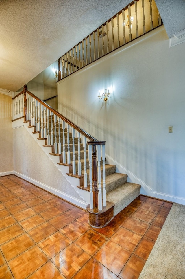 stairway featuring a textured ceiling