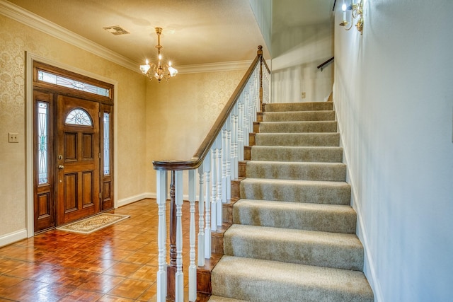 foyer with ornamental molding and a notable chandelier