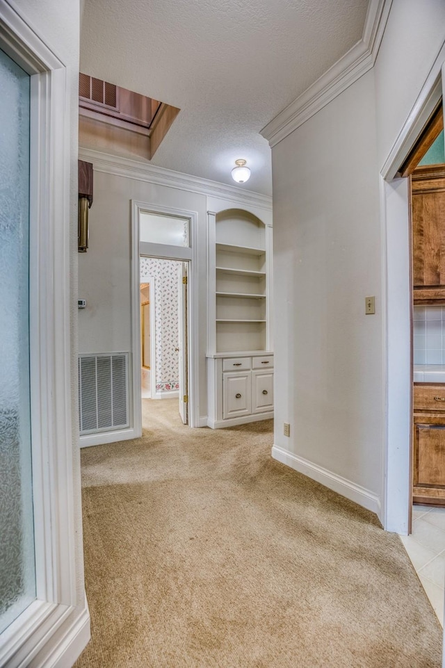 unfurnished living room featuring crown molding, built in features, light carpet, and a textured ceiling