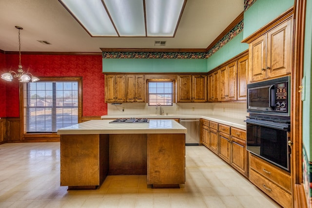 kitchen with sink, an inviting chandelier, a center island, tile counters, and black appliances