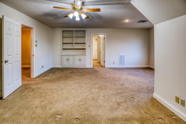 unfurnished living room featuring ceiling fan, light carpet, and a textured ceiling