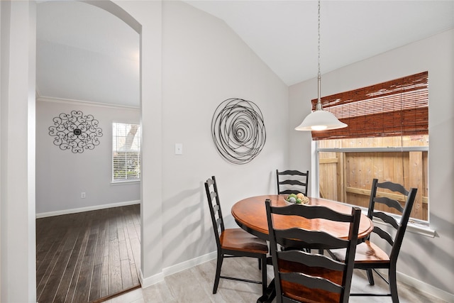 dining area with hardwood / wood-style flooring and vaulted ceiling