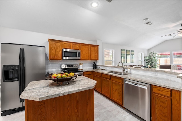 kitchen with lofted ceiling, sink, kitchen peninsula, stainless steel appliances, and backsplash