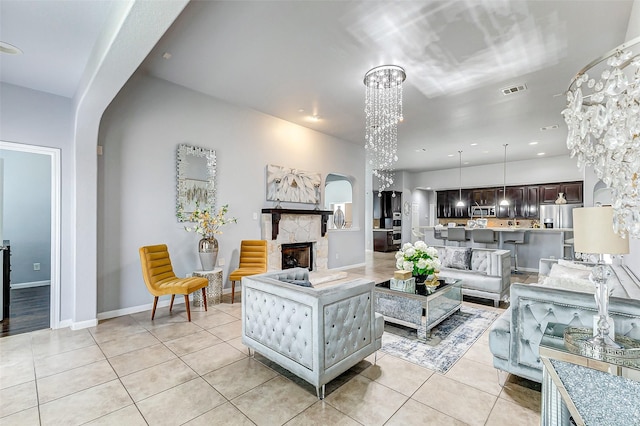 tiled living room with an inviting chandelier and a fireplace