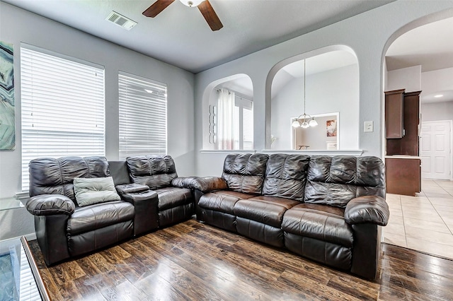 living room with ceiling fan with notable chandelier and wood-type flooring