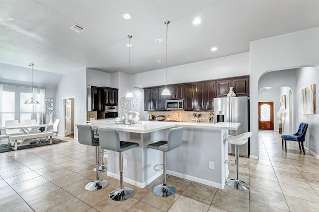 kitchen with pendant lighting, stainless steel appliances, a kitchen breakfast bar, and a spacious island