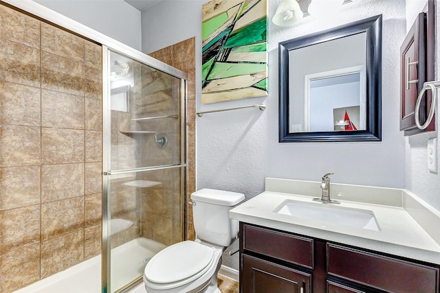 bathroom with vanity, toilet, and an enclosed shower