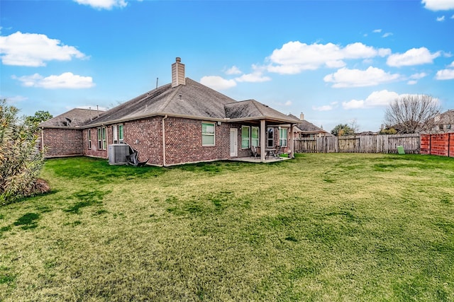 rear view of house featuring a patio area, central AC, and a lawn