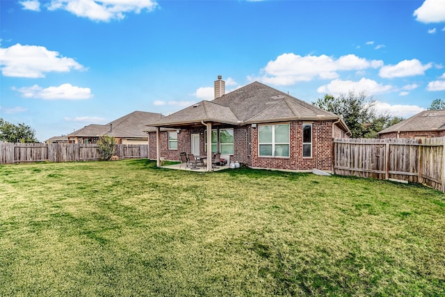 rear view of house with a patio and a lawn