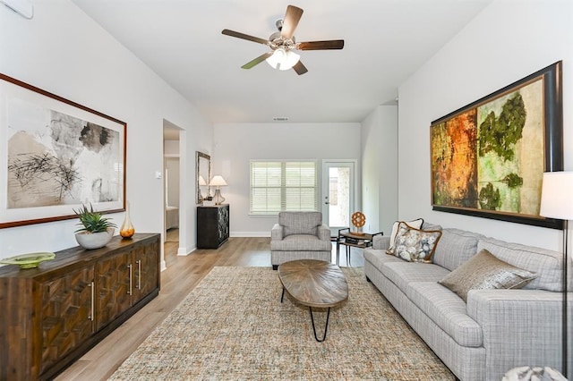 living room with light hardwood / wood-style floors and ceiling fan