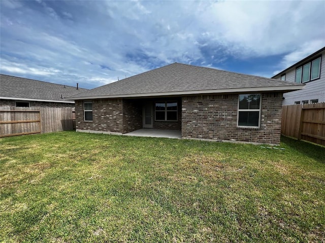 rear view of property featuring a patio and a yard