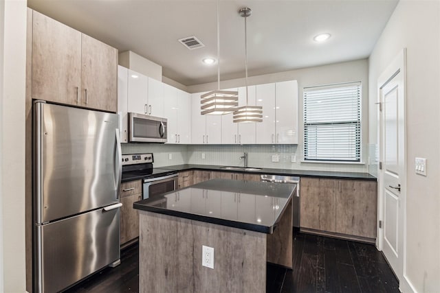 2401 Crawford St Unit A209, Houston, TX 77004 - kitchen with visible vents, dark countertops, dark wood finished floors, appliances with stainless steel finishes, and a sink