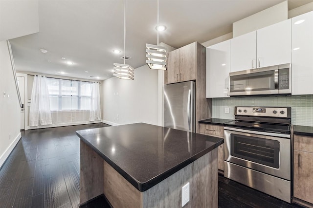 kitchen featuring a kitchen island, white cabinets, dark hardwood / wood-style flooring, decorative backsplash, and stainless steel appliances