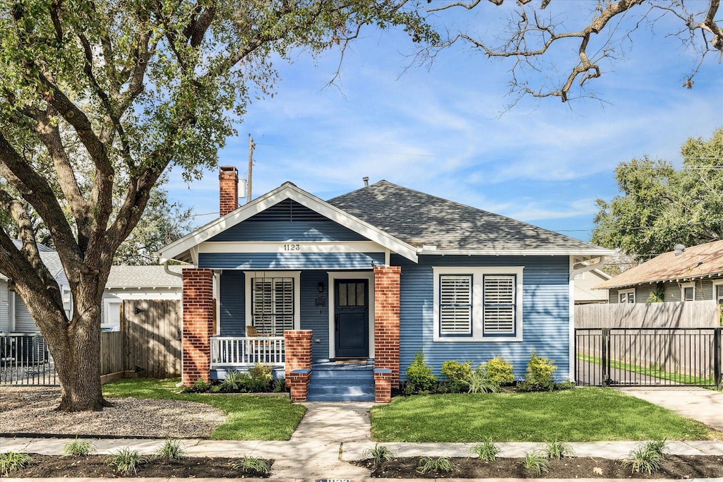 bungalow featuring a front yard and covered porch